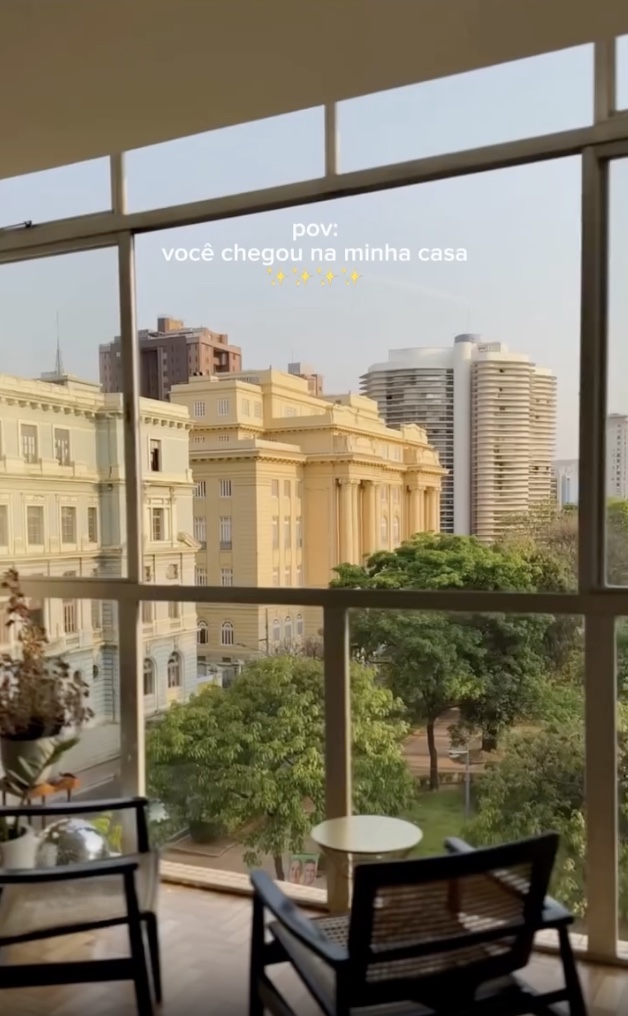 Reel: vista da janela para a Praça da Liberdade, com o texto 'pov: você chegou na minha casa'